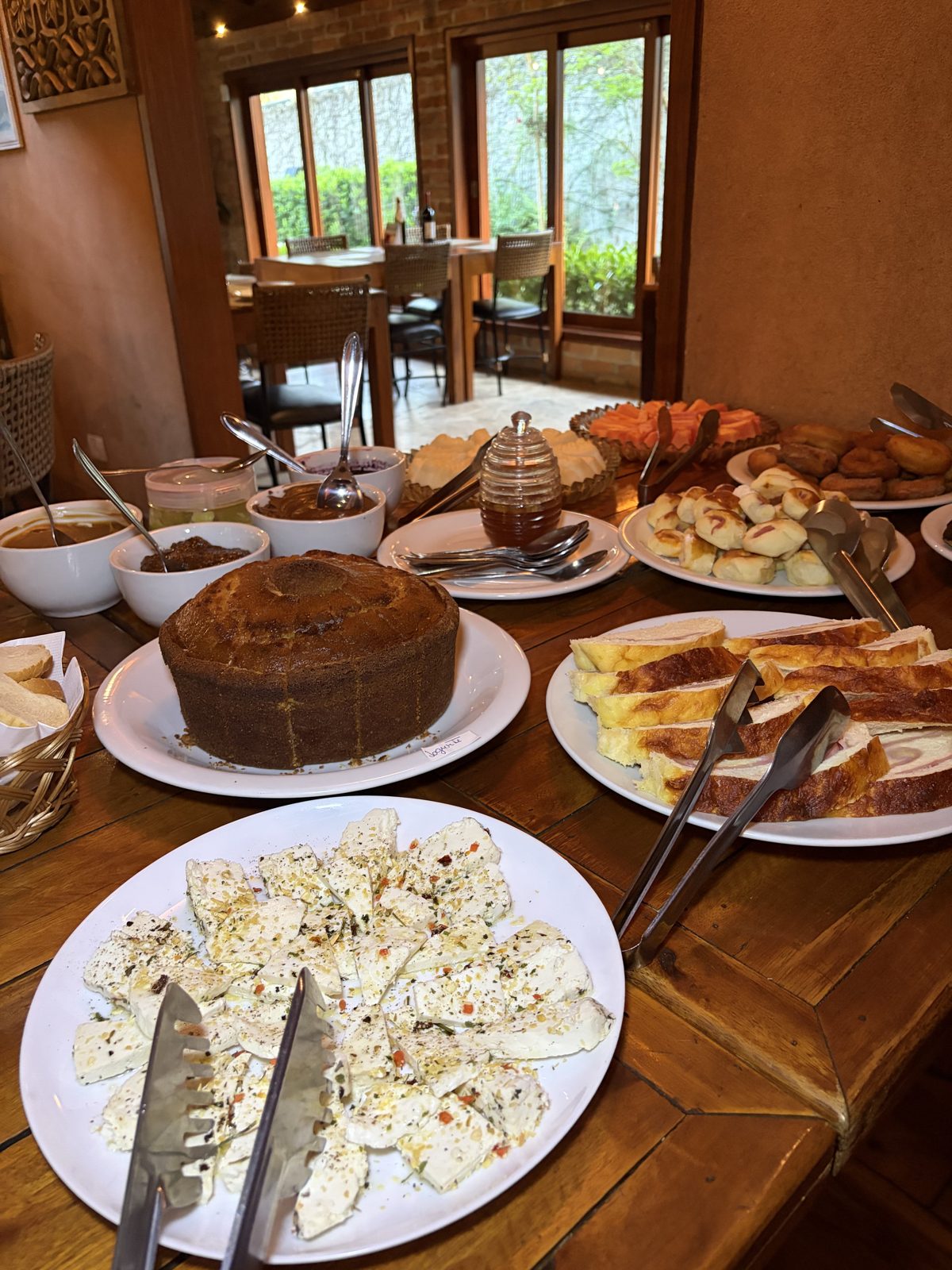 Buffet do Café Colonial do La Bastos, com queijos, pães, bolo e geleias
