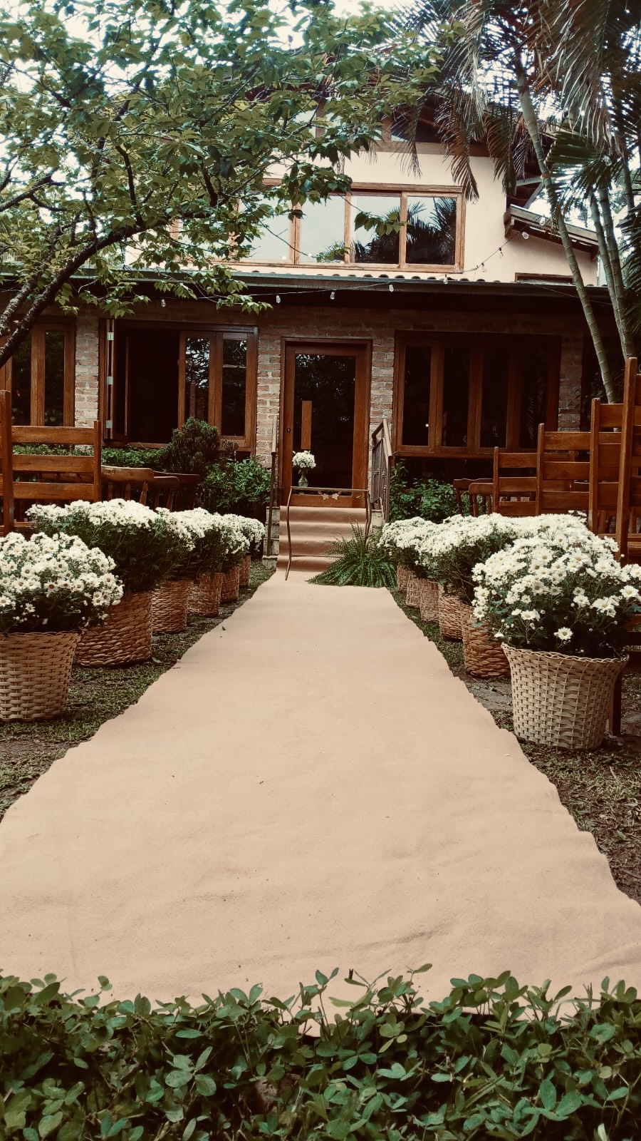 Cerimônia ao ar livre no jardim do La Bastos, com passarela e flores