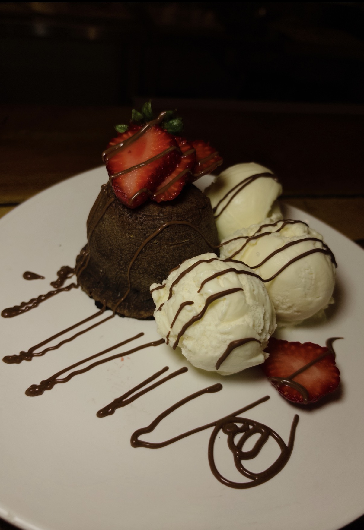 Petit Gâteau do La Bastos com sorvete de creme, calda de chocolate e morangos
